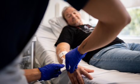 Elderly man receiving medical care for cancer in hospital.