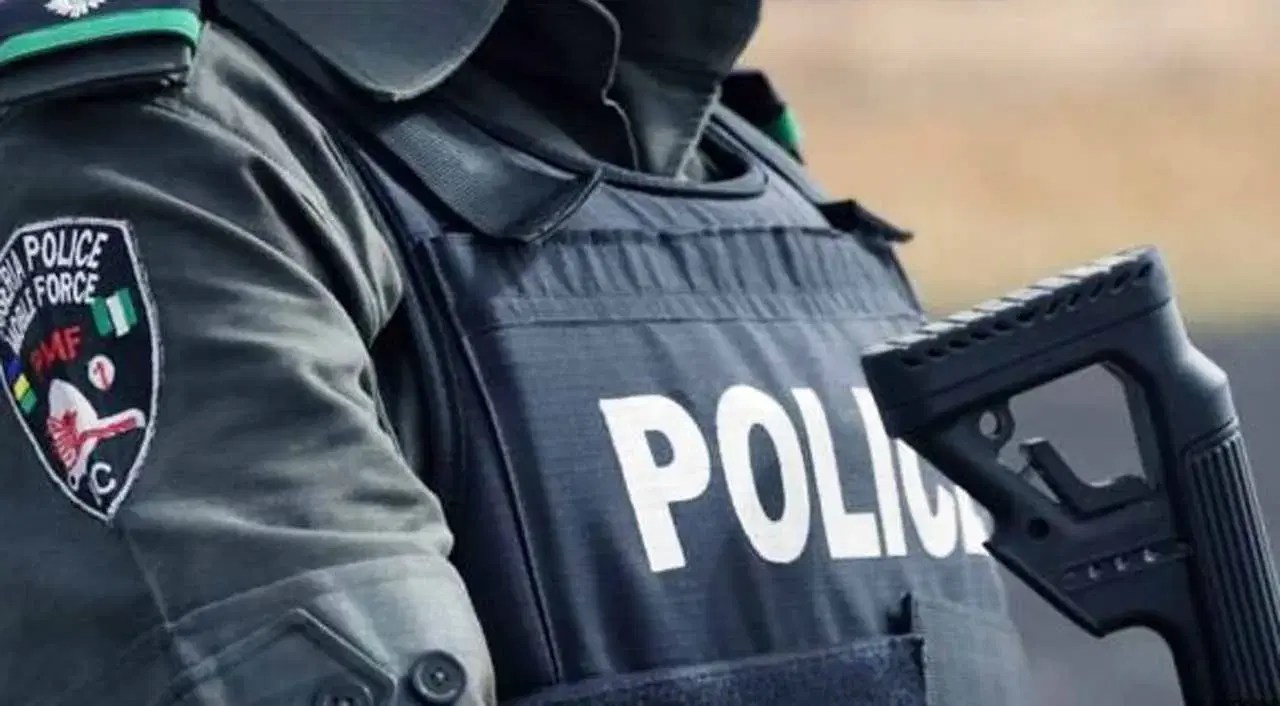 Police officer in tactical gear during manhunt for attackers.