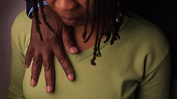 Close-up of a person with a hand on their shoulder, highlighting the issue of campus harassment.